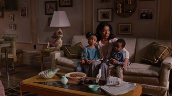 Movie still from “For Colored Girls” (2010), directed by Tyler Perry – A woman sitting on a couch with two children; Medium shot, Over the shoulder angle