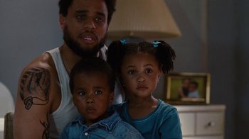 Movie still from “For Colored Girls” (2010), directed by Tyler Perry – A man and two children pose for a picture; Close Up shot, Low angle