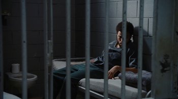 Movie still from “For Colored Girls” (2010), directed by Tyler Perry – Two men sitting on a bed in a jail cell; Wide shot, High angle