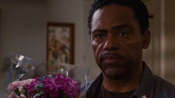 Movie still from “For Colored Girls” (2010), directed by Tyler Perry – A person holding a bouquet of flowers; Close Up shot, Over the shoulder angle
