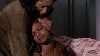 Movie still from “For Colored Girls” (2010), directed by Tyler Perry – A woman holding a woman's head while another woman holds her hand up to her forehead; Close Up shot, High angle