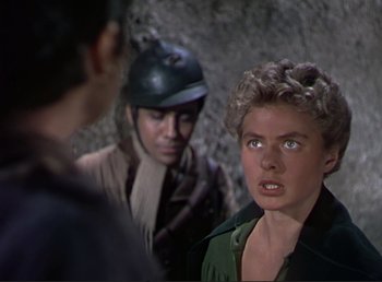 Movie still from “For Whom the Bell Tolls” (1943), directed by Sam Wood – A man and a woman standing next to each other in front of another man; Close Up shot, Over the shoulder angle