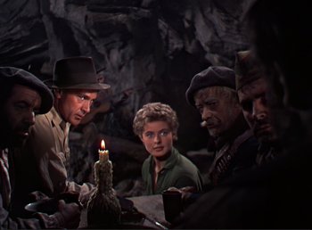 Movie still from “For Whom the Bell Tolls” (1943), directed by Sam Wood – A group of people gathered around a lit candle; Medium shot, High angle