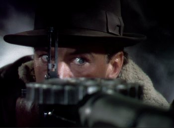 Movie still from “For Whom the Bell Tolls” (1943), directed by Sam Wood – A person wearing a hat looking at a camera; Extreme Close Up shot, Over the shoulder angle