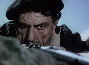Movie still from “For Whom the Bell Tolls” (1943), directed by Sam Wood – A person with a gun; Close Up shot, Low angle