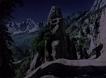 Movie still from “For Whom the Bell Tolls” (1943), directed by Sam Wood – A night scene of a mountain with a rock spire; Extreme Wide shot, High angle