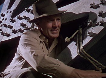 Movie still from “For Whom the Bell Tolls” (1943), directed by Sam Wood – A man wearing a hat and holding a rope; Medium shot, Low angle