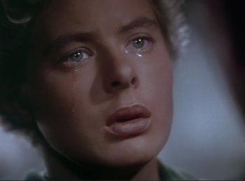 Movie still from “For Whom the Bell Tolls” (1943), directed by Sam Wood – A person with a tear in their eye; Close Up shot, Over the shoulder angle