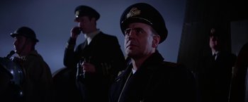 Movie still from “Force 10 from Navarone” (1978), directed by Guy Hamilton – A man in a uniform and a man in a hat; Medium shot, Low angle