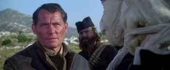 Movie still from “Force 10 from Navarone” (1978), directed by Guy Hamilton – A man with a beard wearing a hat; Close Up shot, Over the shoulder angle