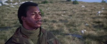 Movie still from “Force 10 from Navarone” (1978), directed by Guy Hamilton – A man in a field looking up at the sky; Close Up shot, Low angle