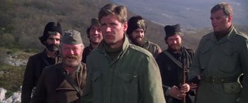Movie still from “Force 10 from Navarone” (1978), directed by Guy Hamilton – A group of men standing next to each other on top of a hill; Medium shot, Low angle