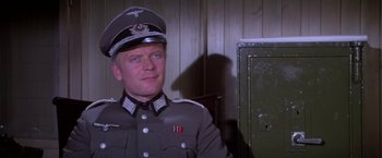 Movie still from “Force 10 from Navarone” (1978), directed by Guy Hamilton – A man in a military uniform is standing in front of a wall; Close Up shot, Low angle