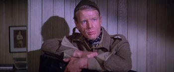 Movie still from “Force 10 from Navarone” (1978), directed by Guy Hamilton – A man wearing a hat and a jacket; Close Up shot, Over the shoulder angle