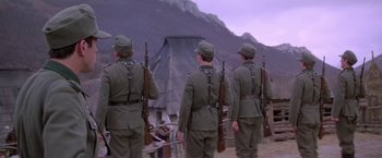 Movie still from “Force 10 from Navarone” (1978), directed by Guy Hamilton – A group of men standing next to each other holding guns; Wide shot, Low angle