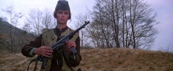 Movie still from “Force 10 from Navarone” (1978), directed by Guy Hamilton – A woman holding a rifle in a field; Medium shot, Low angle
