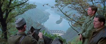 Movie still from “Force 10 from Navarone” (1978), directed by Guy Hamilton – A person on a horse looking down at a lake; Wide shot, High angle