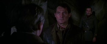 Movie still from “Force 10 from Navarone” (1978), directed by Guy Hamilton – A man is looking into a mirror in a cave; Close Up shot, Over the shoulder angle