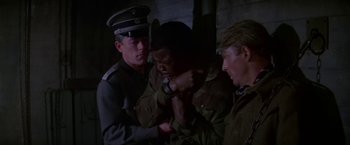 Movie still from “Force 10 from Navarone” (1978), directed by Guy Hamilton – A group of men standing next to each other in a room; Medium shot, High angle