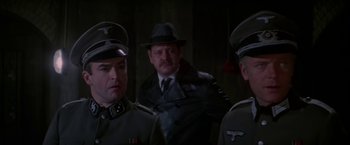 Movie still from “Force 10 from Navarone” (1978), directed by Guy Hamilton – A group of men standing next to each other wearing hats; Close Up shot, Over the shoulder angle