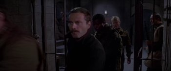 Movie still from “Force 10 from Navarone” (1978), directed by Guy Hamilton – A group of people standing next to each other in a room; Medium shot, Over the shoulder angle