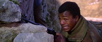 Movie still from “Force 10 from Navarone” (1978), directed by Guy Hamilton – A man holding a pair of scissors next to a tree; Close Up shot, Over the shoulder angle