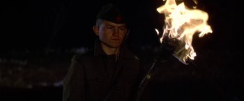 Movie still from “Force 10 from Navarone” (1978), directed by Guy Hamilton – A man in a military uniform holding a lit stick; Close Up shot, Low angle