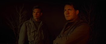 Movie still from “Force 10 from Navarone” (1978), directed by Guy Hamilton – A couple of men standing next to each other in the dark; Close Up shot, Low angle