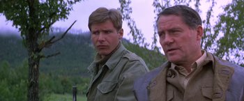 Movie still from “Force 10 from Navarone” (1978), directed by Guy Hamilton – A man in a field with another man standing next to him; Close Up shot, Low angle