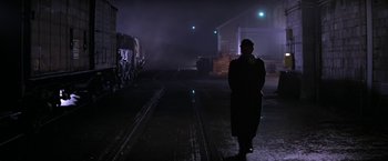 Movie still from “Force 10 from Navarone” (1978), directed by Guy Hamilton – A man standing on the side of a train track at night; Wide shot, Low angle