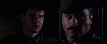 Movie still from “Force 10 from Navarone” (1978), directed by Guy Hamilton – Two men are standing next to each other in the dark; Close Up shot, Low angle