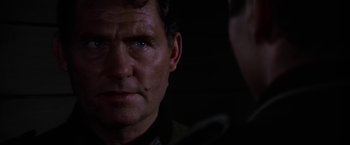 Movie still from “Force 10 from Navarone” (1978), directed by Guy Hamilton – A man's face in the dark; Close Up shot, Over the shoulder angle