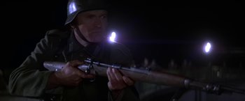 Movie still from “Force 10 from Navarone” (1978), directed by Guy Hamilton – A man holding a rifle with a light on it's head; Close Up shot, Low angle