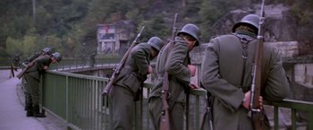 Movie still from “Force 10 from Navarone” (1978), directed by Guy Hamilton – A group of men standing next to each other holding guns; Wide shot, Low angle