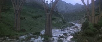 Movie still from “Force 10 from Navarone” (1978), directed by Guy Hamilton – A tree in the middle of a river with mountains in the background; Extreme Wide shot, Low angle