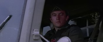 Movie still from “Force 10 from Navarone” (1978), directed by Guy Hamilton – A man in a uniform sitting in a vehicle; Close Up shot, Low angle