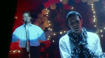 Movie still from “Forces of Nature” (1999), directed by Bronwen Hughes – Two young men are performing in a nightclub; Medium shot, Low angle