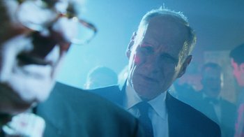 Movie still from “Forces of Nature” (1999), directed by Bronwen Hughes – An older man wearing a suit and tie; Close Up shot, Over the shoulder angle