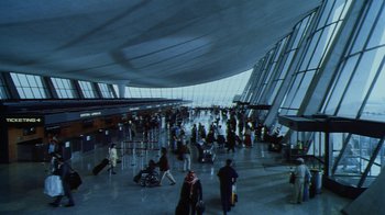 Movie still from “Forces of Nature” (1999), directed by Bronwen Hughes – A large group of people in an airport terminal; Extreme Wide shot, High angle