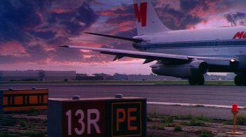 Movie still from “Forces of Nature” (1999), directed by Bronwen Hughes – An airplane on the runway at sunset; Wide shot, Low angle