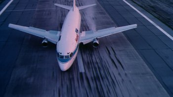 Movie still from “Forces of Nature” (1999), directed by Bronwen Hughes – An airplane on a runway with the landing gear down; Extreme Wide shot, Overhead angle