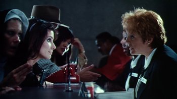 Movie still from “Forces of Nature” (1999), directed by Bronwen Hughes – A group of people sitting at a table talking to each other; Medium shot, Over the shoulder angle