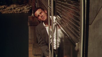Movie still from “Forces of Nature” (1999), directed by Bronwen Hughes – A man in a suit leaning against a metal wall; Medium shot, Low angle