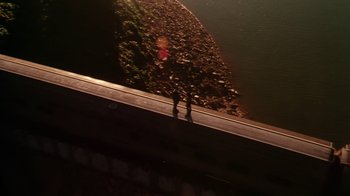 Movie still from “Forces of Nature” (1999), directed by Bronwen Hughes – Two skateboarders standing on the side of a road; Extreme Wide shot, Overhead angle
