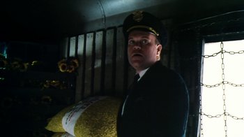 Movie still from “Forces of Nature” (1999), directed by Bronwen Hughes – A man wearing a uniform and a hat is standing next to a bed; Close Up shot, Low angle