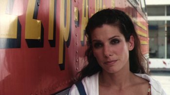 Movie still from “Forces of Nature” (1999), directed by Bronwen Hughes – A beautiful woman standing in front of a train car; Close Up shot, Low angle