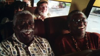 Movie still from “Forces of Nature” (1999), directed by Bronwen Hughes – A group of people sitting in a car; Medium shot, High angle