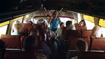 Movie still from “Forces of Nature” (1999), directed by Bronwen Hughes – A man riding a bike on the back of a tour bus; Wide shot, High angle