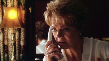 Movie still from “Forces of Nature” (1999), directed by Bronwen Hughes – An older woman talking on a phone in front of a mirror; Close Up shot, Low angle