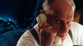 Movie still from “Forces of Nature” (1999), directed by Bronwen Hughes – An older man talking on a phone while sitting down; Close Up shot, Low angle